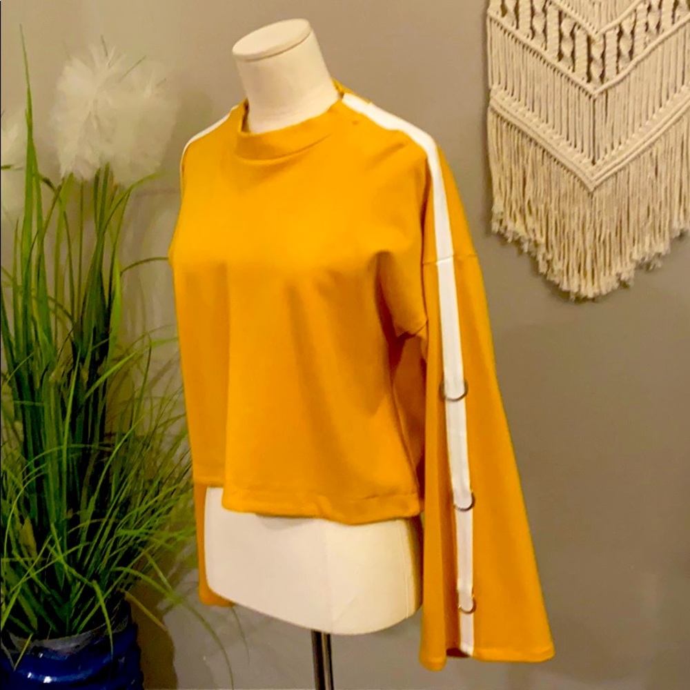 Mustard top with metal hoops on sleeves